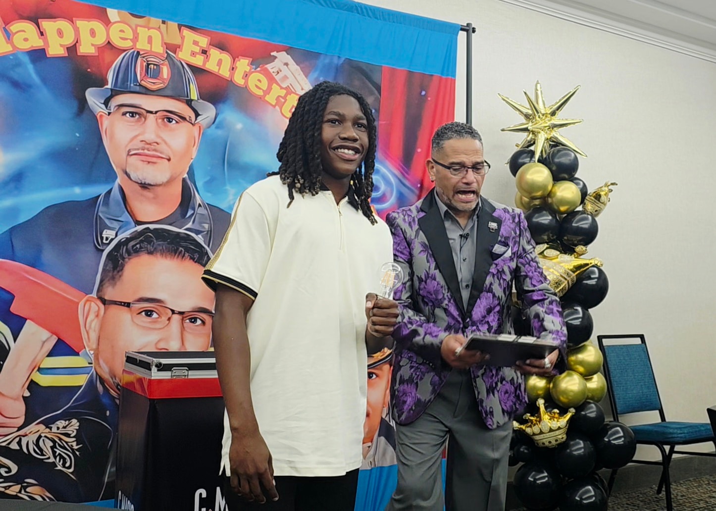 Two men at event celebration with banner