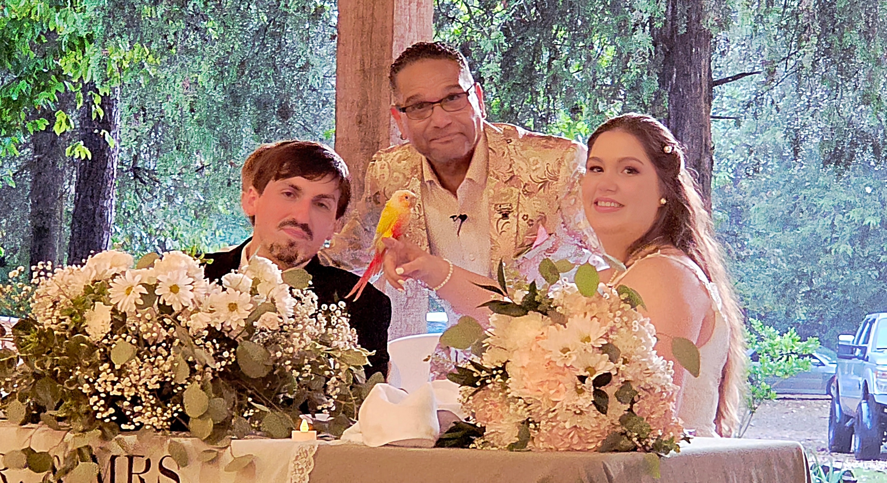 C. Magic with bride and groom at sweetheart table with Starbust the Conure