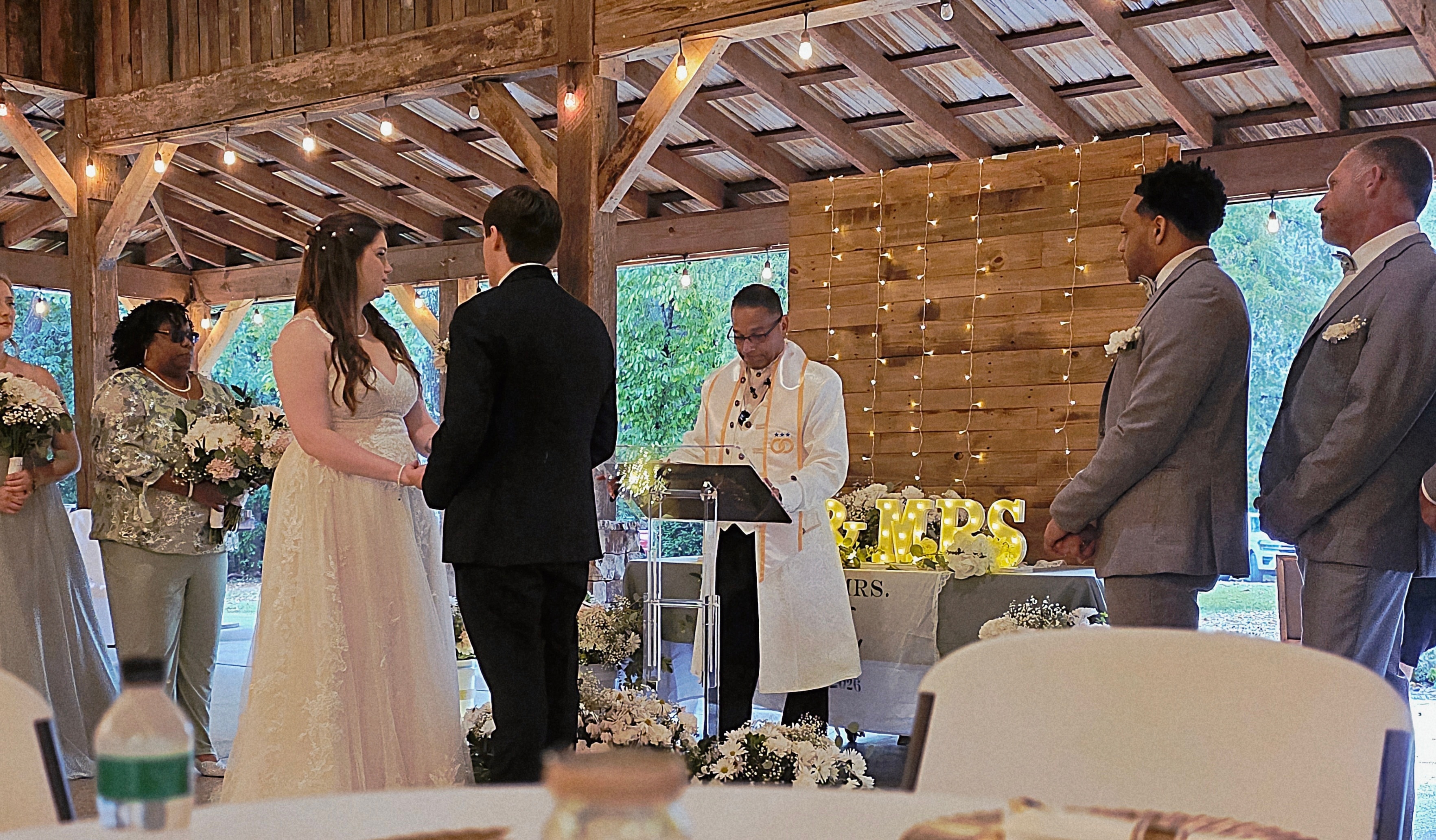 C. Magic officiating as bride and groom hold hands at the altar