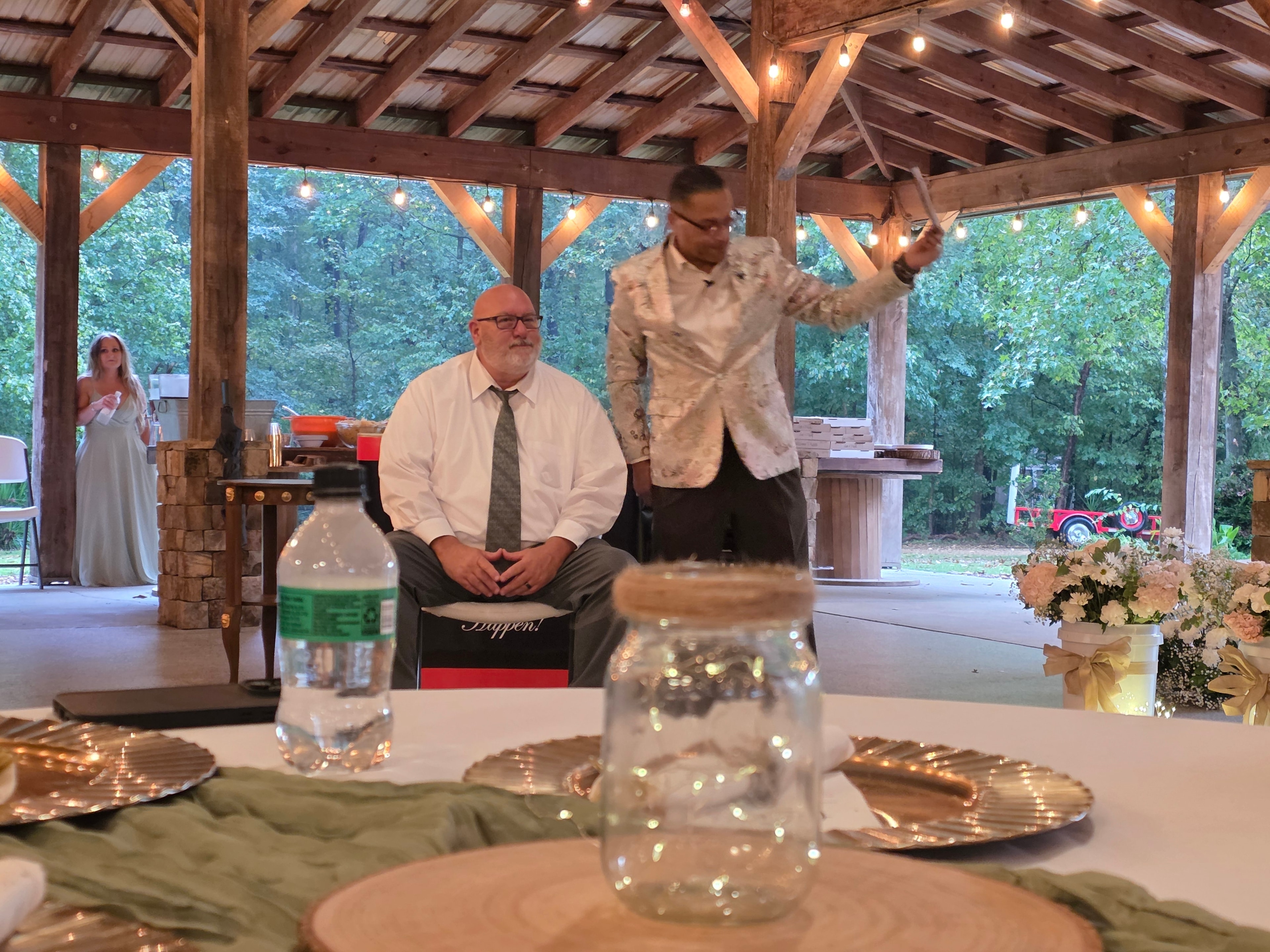 C. Magic performing magic trick over seated guest at the Allen wedding pavilion