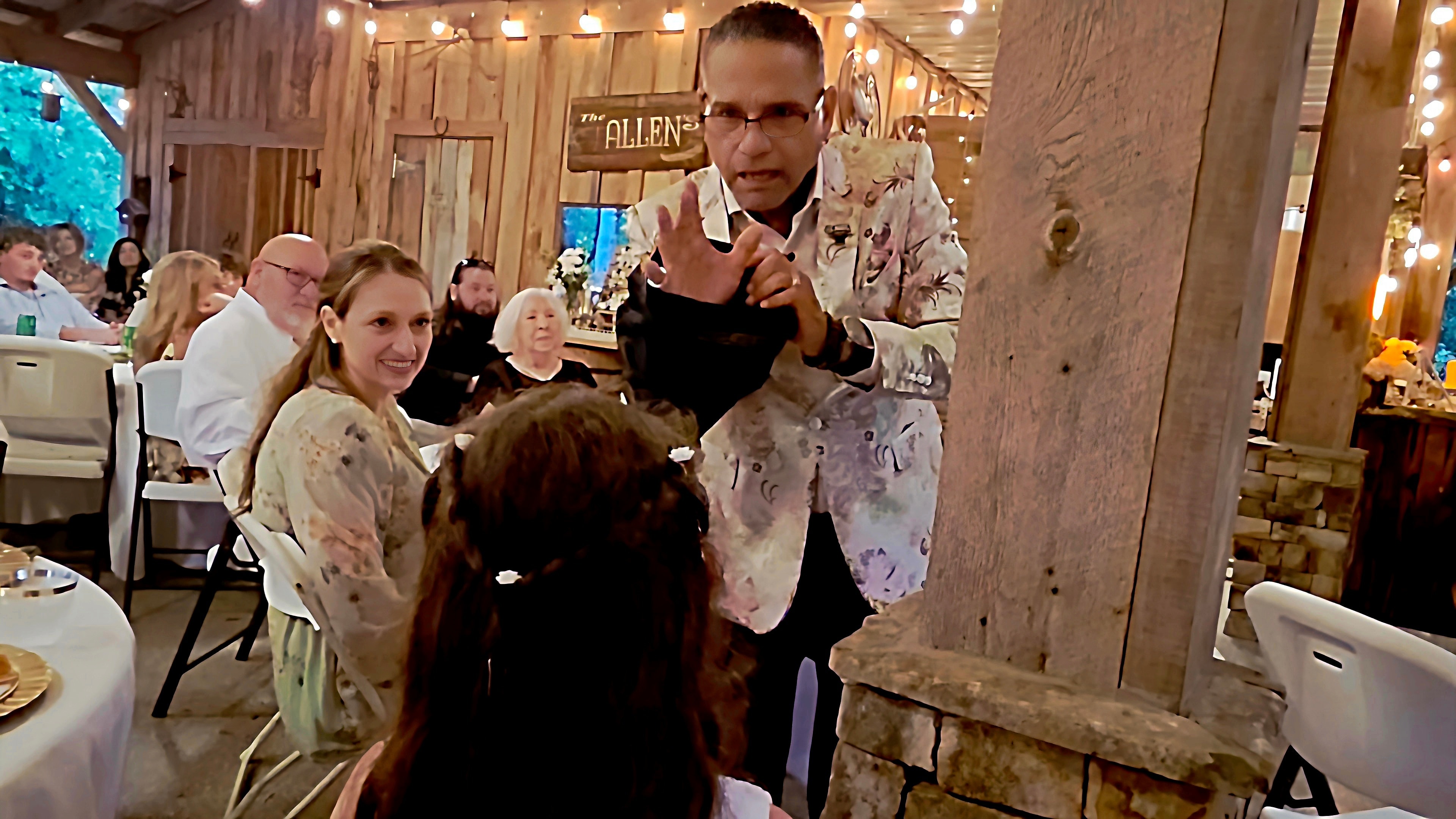 C. Magic performing close-up magic for woman and child at the Allen wedding reception