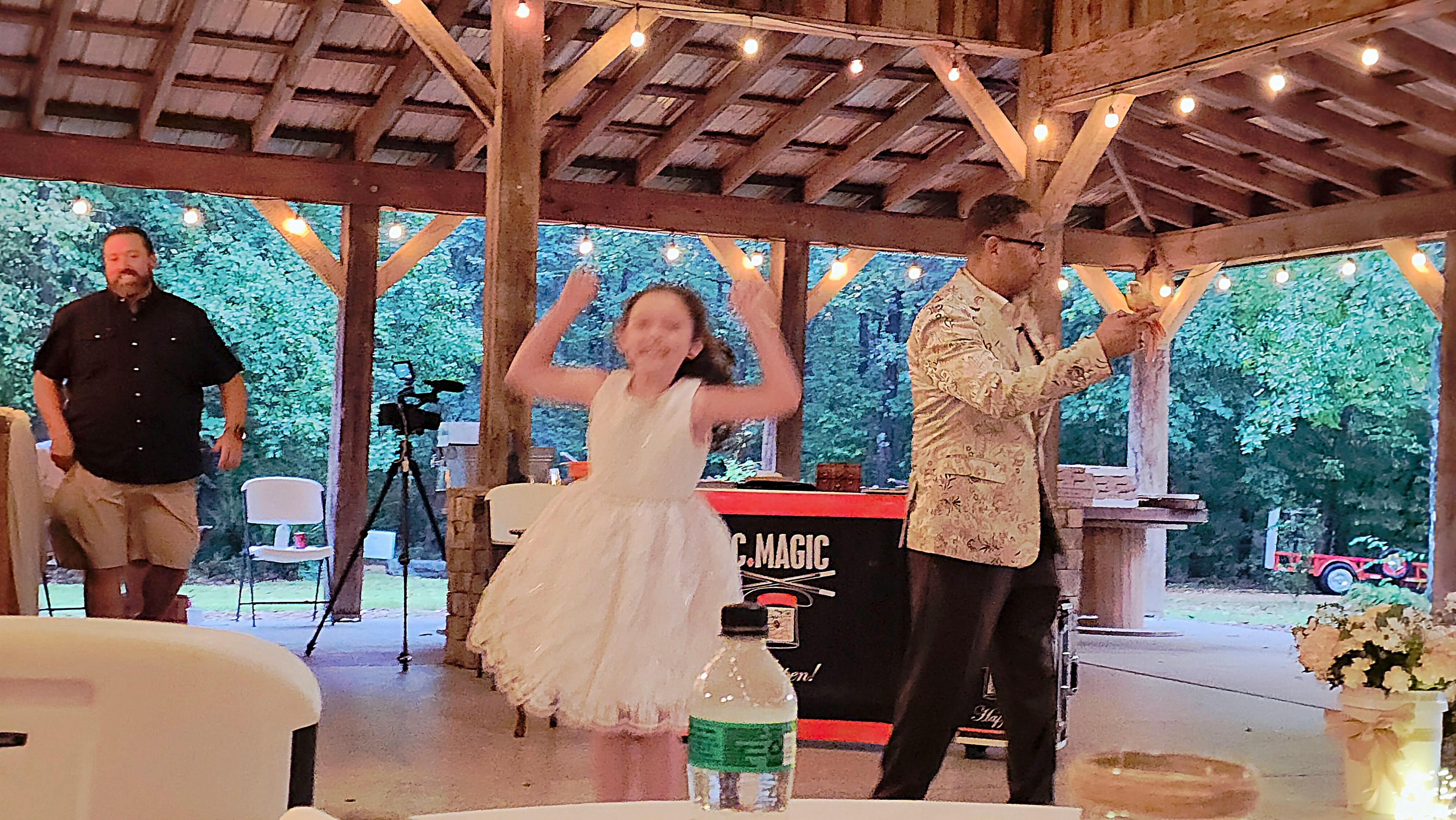 Excited young girl jumping for joy after C. Magic's Starbust trick at C. Magic Happen table